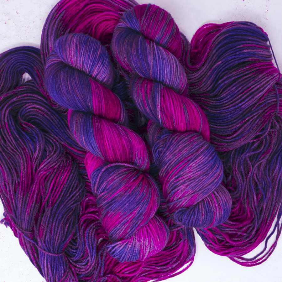 Bewitched hand-dyed yarn featuring rich magenta, violet and lilac tones with dramatic tonal variation and magical depth.