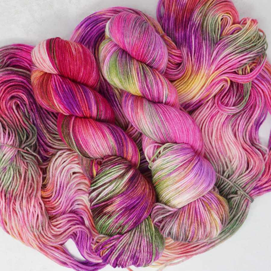 Field of Dreams hand-dyed yarn featuring floral pink, coral and lilac tones with delicate speckles on luxury merino silk yarn by Market Town Yarns.