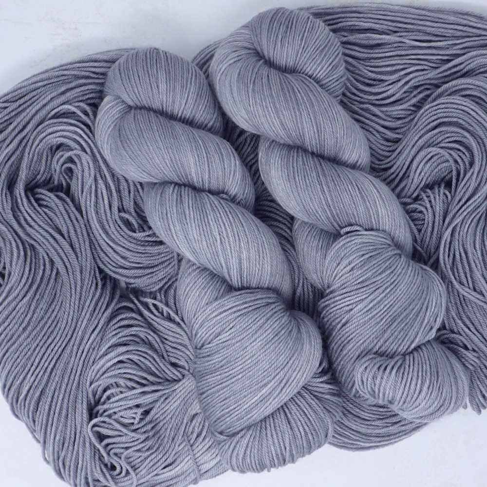 High Tide hand-dyed yarn featuring soft sea-grey and silvery coastal tones on luxury yarn bases by Market Town Yarns.
